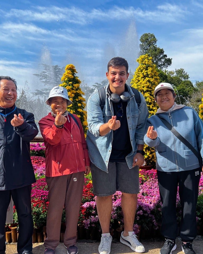 هشام مع زوار محليين في حديقة صينية — Hesham with local visitors at a Chinese garden